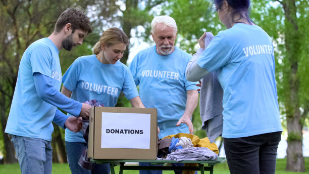 istock Volunteers sorting clothes putting in donation box, philanthropic organization 1176496711