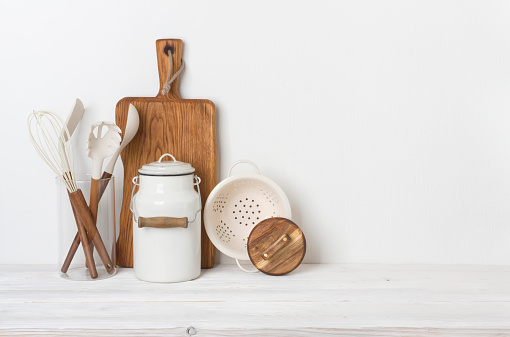 Kitchen utensils on background of wooden table and white wall