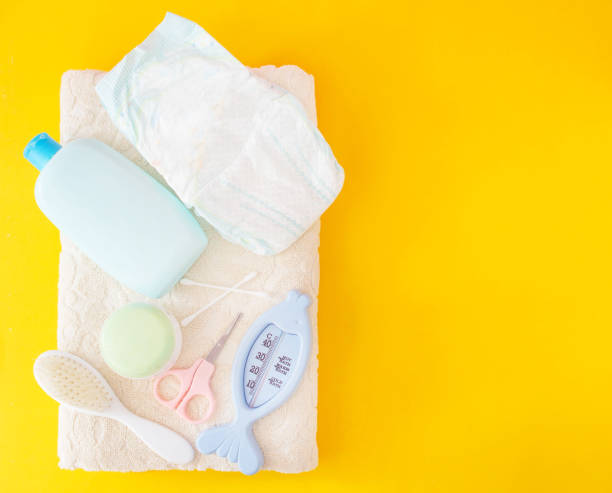 istock Baby bathing accessories, diaper, yellow background 1176497574