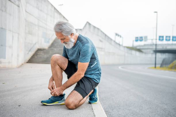 istock Senior man tying his shoelaces before running 1176498172
