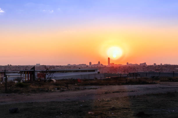 Cityscape of Alexandra Township at sunset in the evening with Sandton City skyscrapers seen in the distance. Alexandra also known as Alex was developed since 1912 and allocated for the africans in the apartheid era, it is now home to over 400 000 inhabitants in an area 7,6 km2, and forms part of Johannesburg city council.