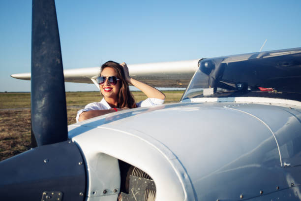 istock Female pilot in sunglasses with modern small aircraft in background 1176507420