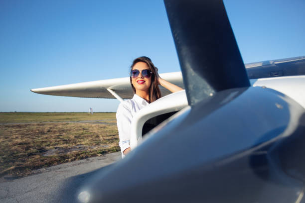 istock Female pilot in sunglasses with modern small aircraft in background 1176507455