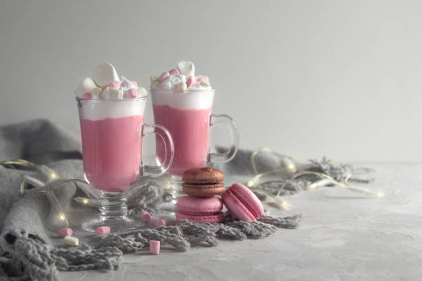 istock Pink hot chocolate winter drink with whipped cream and marshmallows. Macaroons and lights. Copy Space 1176508679