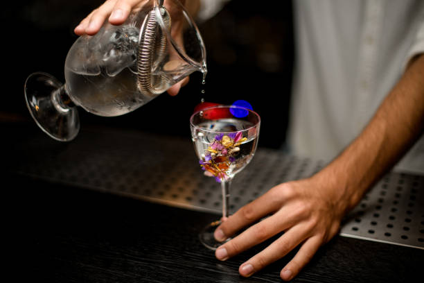 istock Bartender pours cocktail from glass with a strainer 1176509593