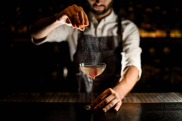 istock Bartender sprinkles alcohol in glass on a counter 1176509726