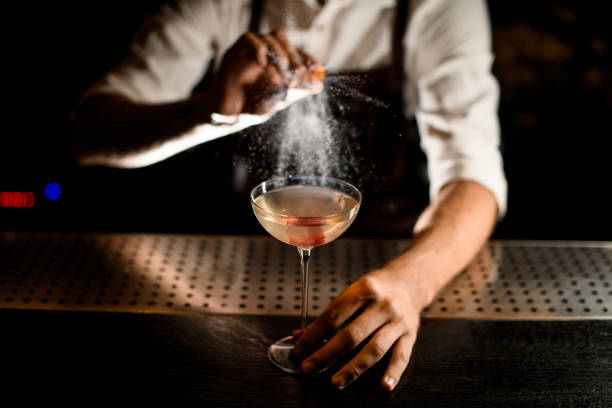istock Bartender sprinkles cocktail in glass on a counter 1176509805