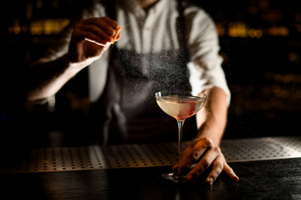 istock Bartender sprinkling an alcohol in glass on counter 1176510506