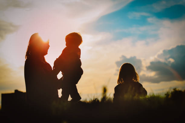 istock happy mother and two daughters play in sunset nature 1176510901