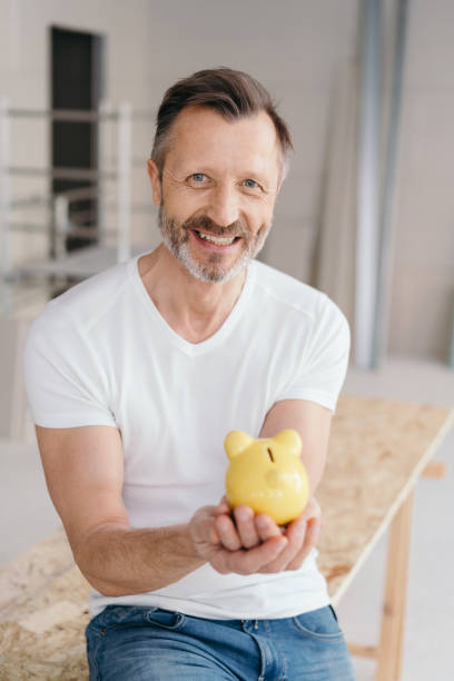 istock Smiling successful man holding a piggy bank 1176510960
