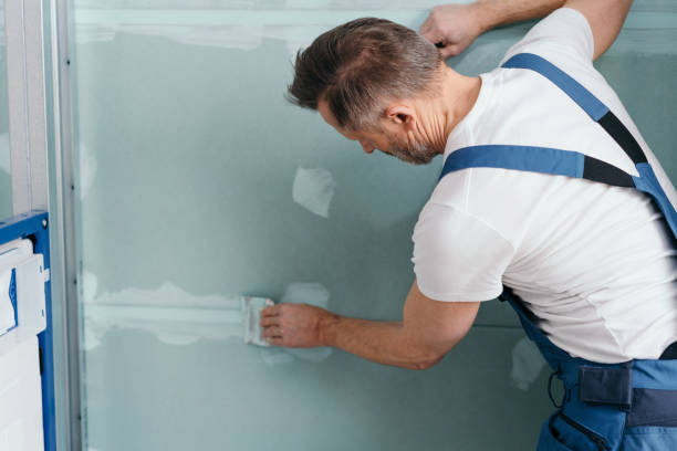 Applying putty to the gypsum plasterboards