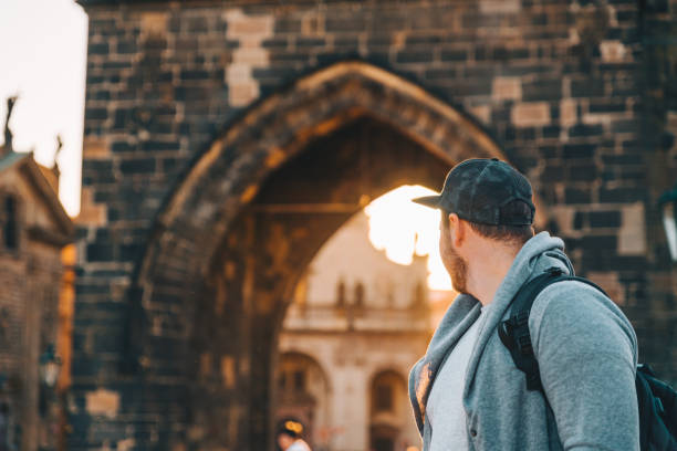 man in front of charles bridge in prague