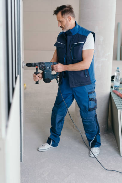 istock Handyman exerting force to drill a hole in a wall 1176511793