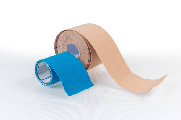 Blue and flesh-colored elastic therapeutic tapes on light surface