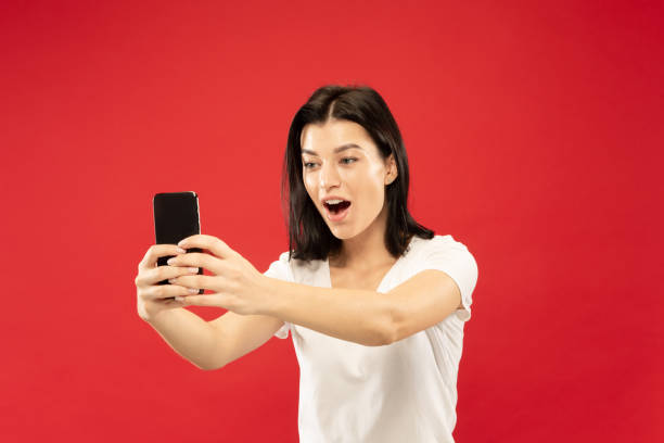 istock Caucasian young woman's half-length portrait on red background 1176512601