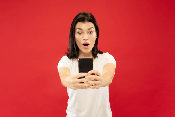 istock Caucasian young woman's half-length portrait on red background 1176512690