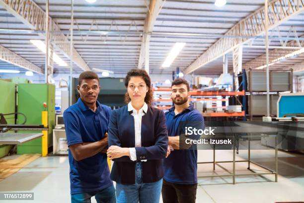 Confident Manager And Workers In Factory Stock Photo - Download Image Now - Serious, Factory, Looking At Camera