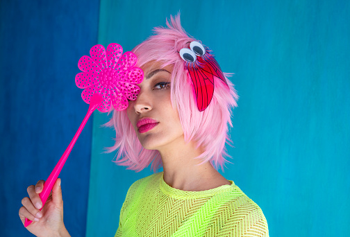 Fashion funny pink hair girl with flyswatter and fly in her hair