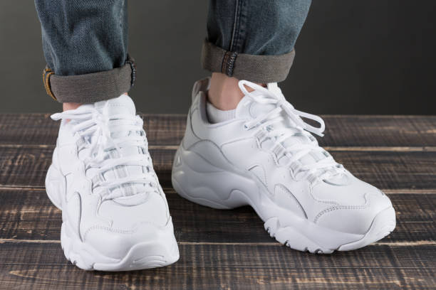 istock white high sneakers on female legs, concept 1176515504