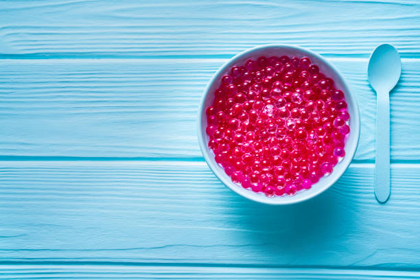 Pink spherification futuristic food concept on light blue wooden table