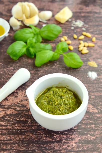 istock Fresh basil pesto on wooden background 1176517578