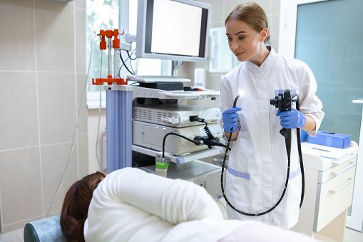 Doctor is doing endoscopy procedure for female in modern hospital office. Website banner