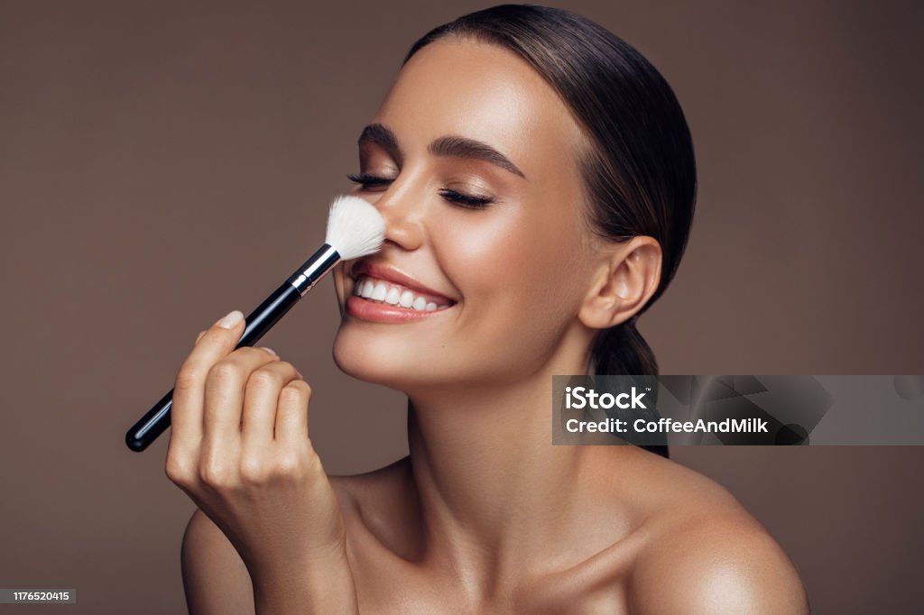 Beautiful woman applying make-up Make-Up Stock Photo