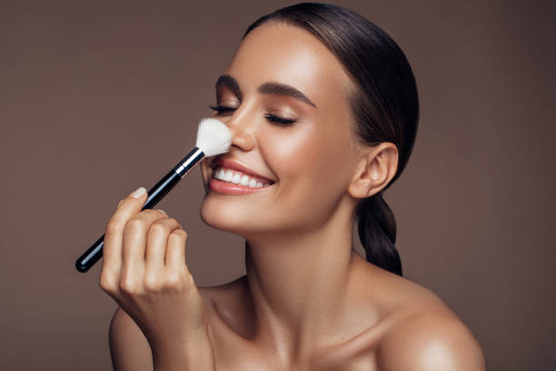 beautiful woman applying make-up - make up cosmetics women make up brush imagens e fotografias de stock