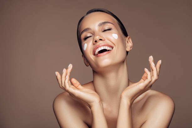 istock Beautiful woman applying cream on her face 1176521644