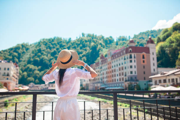 Happy girl at hat on the embankment of a mountain river in a European city. Beautiful woman in hat on the embankment of a mountain river sochi stock pictures, royalty-free photos & images