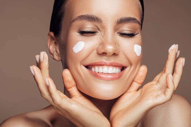 istock Beautiful woman applying cream on her face 1176523512