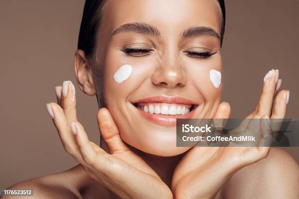 Beautiful Woman Applying Cream On Her Face Stock Photo - Download Image Now - Moisturizer, Women, Human Face