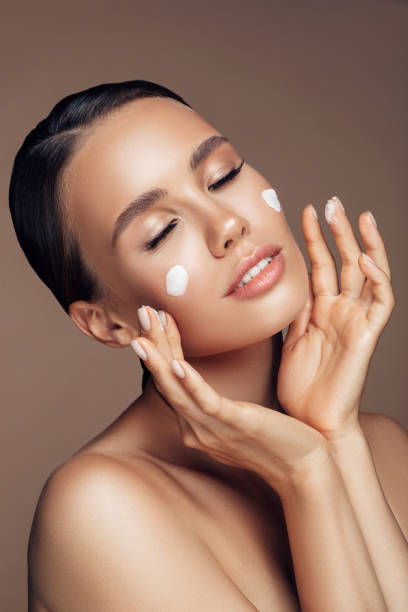 istock Beautiful woman applying cream on her face 1176523562