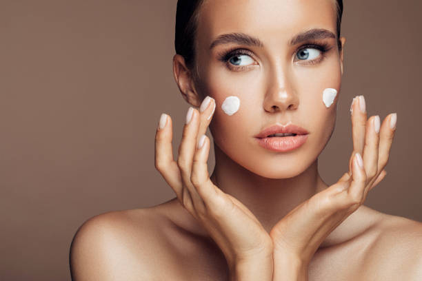 istock Beautiful woman applying cream on her face 1176523639