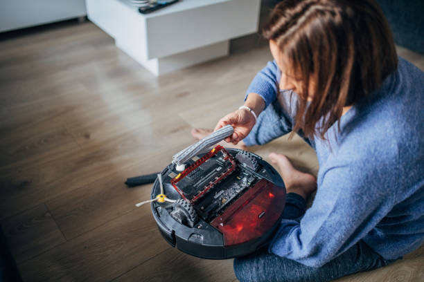 istock Woman cleaning robot vacuum cleaner 1176523657