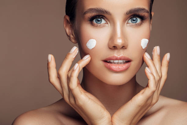 istock Beautiful woman applying cream on her face 1176523676