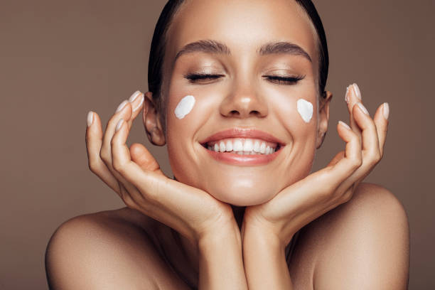istock Beautiful woman applying cream on her face 1176523720