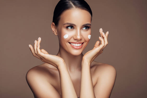 istock Beautiful woman applying cream on her face 1176523778