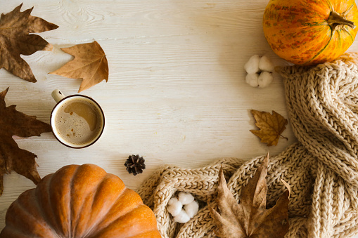 Thanksgiving background concept. Local produce pumpkin and autumn leaves with other decoration on textured table. Close up, copy space for text, top view, flat lay.