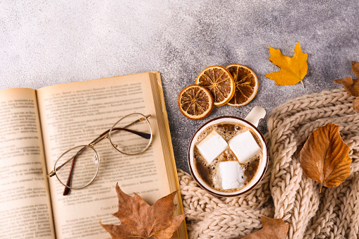 Top view composition with vintage styled cup of coffee and autumn themed decoration, fallen leaves on textured background. Top view, flat lay, copy space.