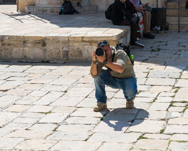 турист находится недалеко от баб-эль-матарак и фотографирует купол скалы в старом городе в иерусалиме, израиль - el aqsa стоковые фото и изображения