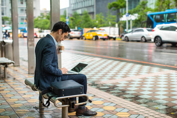 istock Busy man drinking coffee and using laptop on the bus station 1176527423