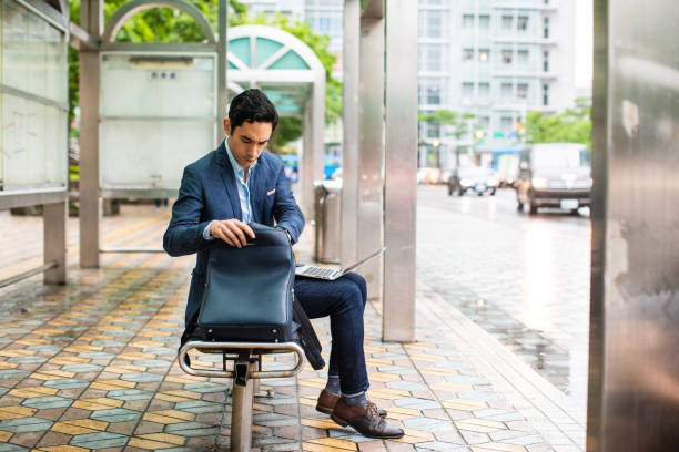 istock Businessman sitting on bus station and using laptop 1176527532