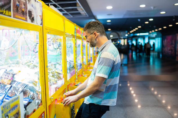 istock Man Playing the Claw Game in an Arcade 1176527627