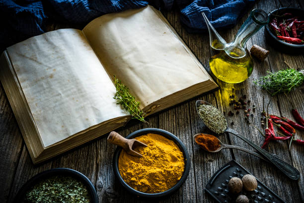 Cookbook and spices on rustic wooden table