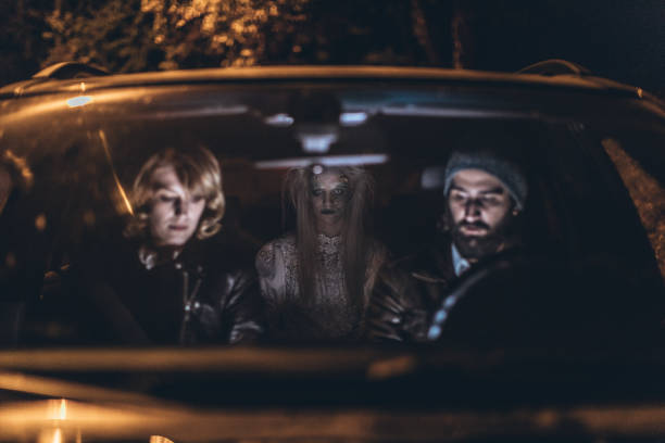 Scary halloween night Man and woman sitting in a car, witch is sitting behind them, halloween night. couple driving at night stock pictures, royalty-free photos & images