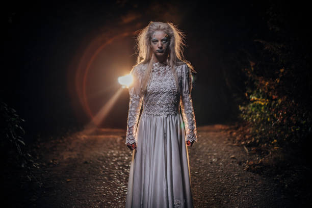 istock Terrifying witch standing on the road at night 1176529258
