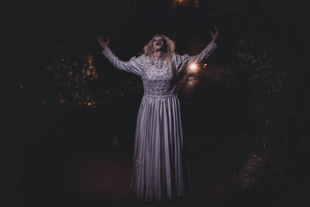 istock Scary witch standing on the road at night 1176529664