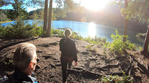 istock Couple hike towards forested lakeshore 1176531017