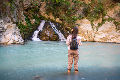 Young brunette tourist woman in nature with backpack